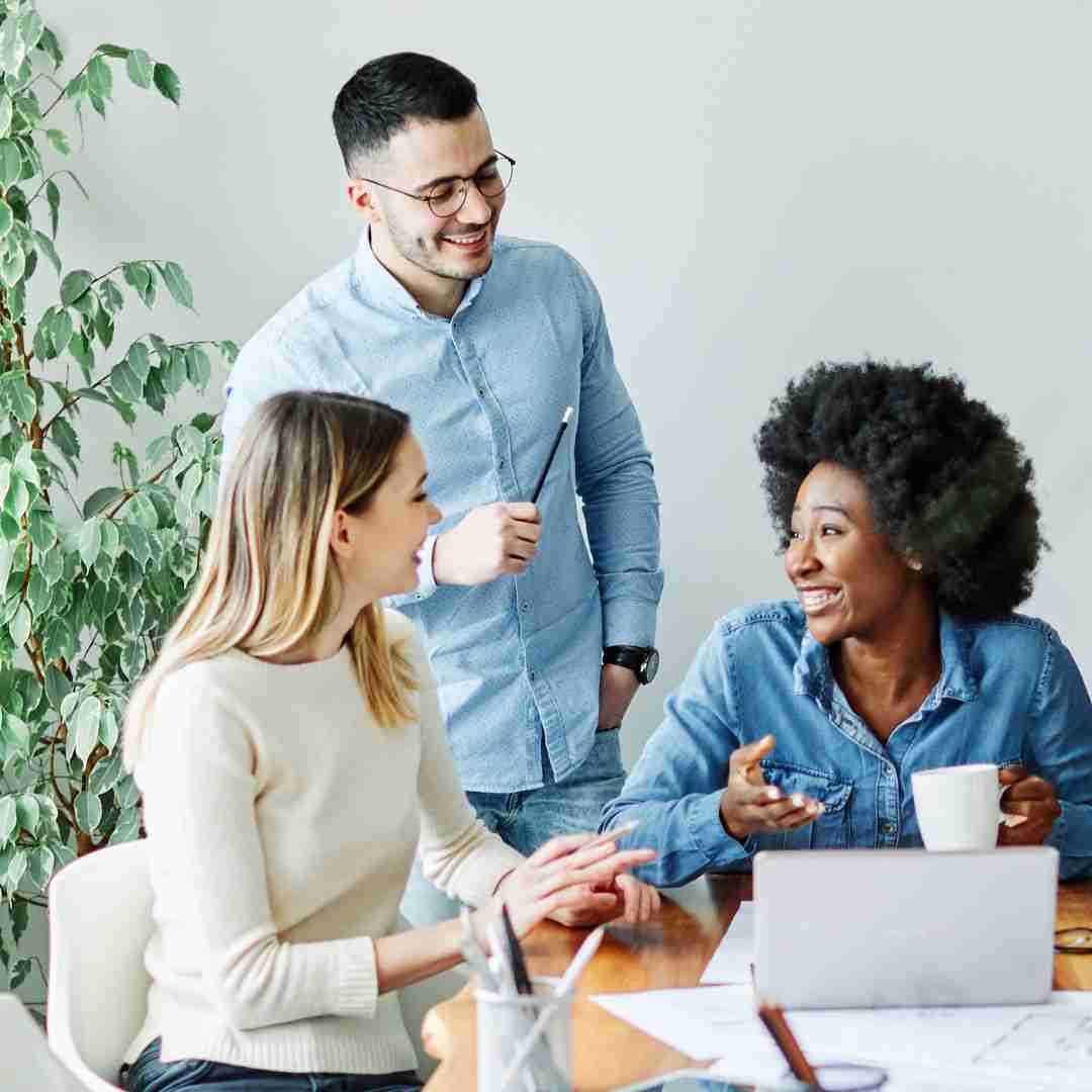 three people talking in an informal office setting