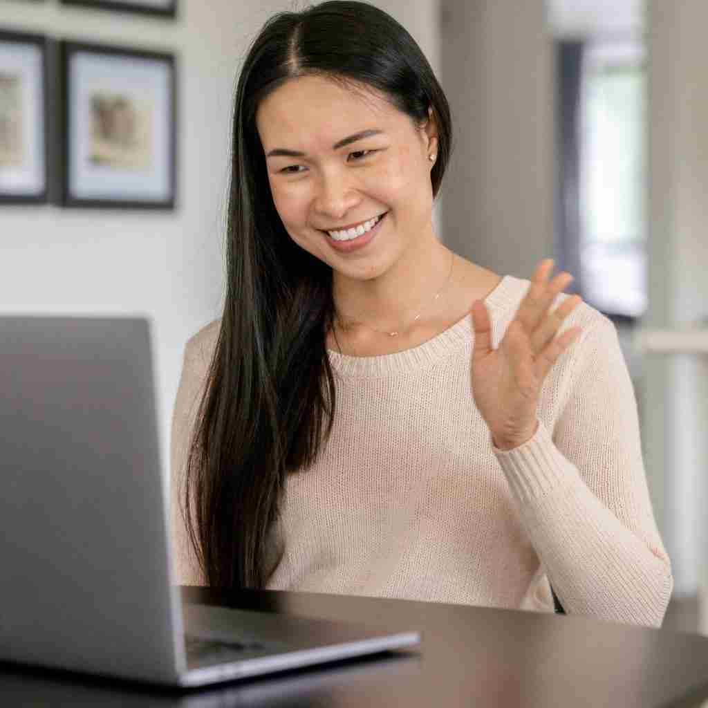 woman waving at computer